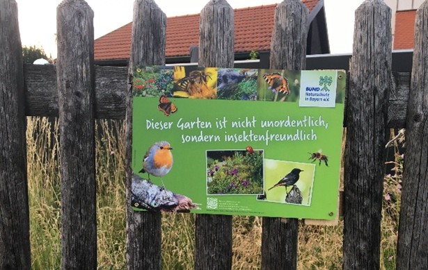 Hinweisschild am Gartenzaun: Dieser Garten ist nicht unordentlich, sondern insektenfreundlich